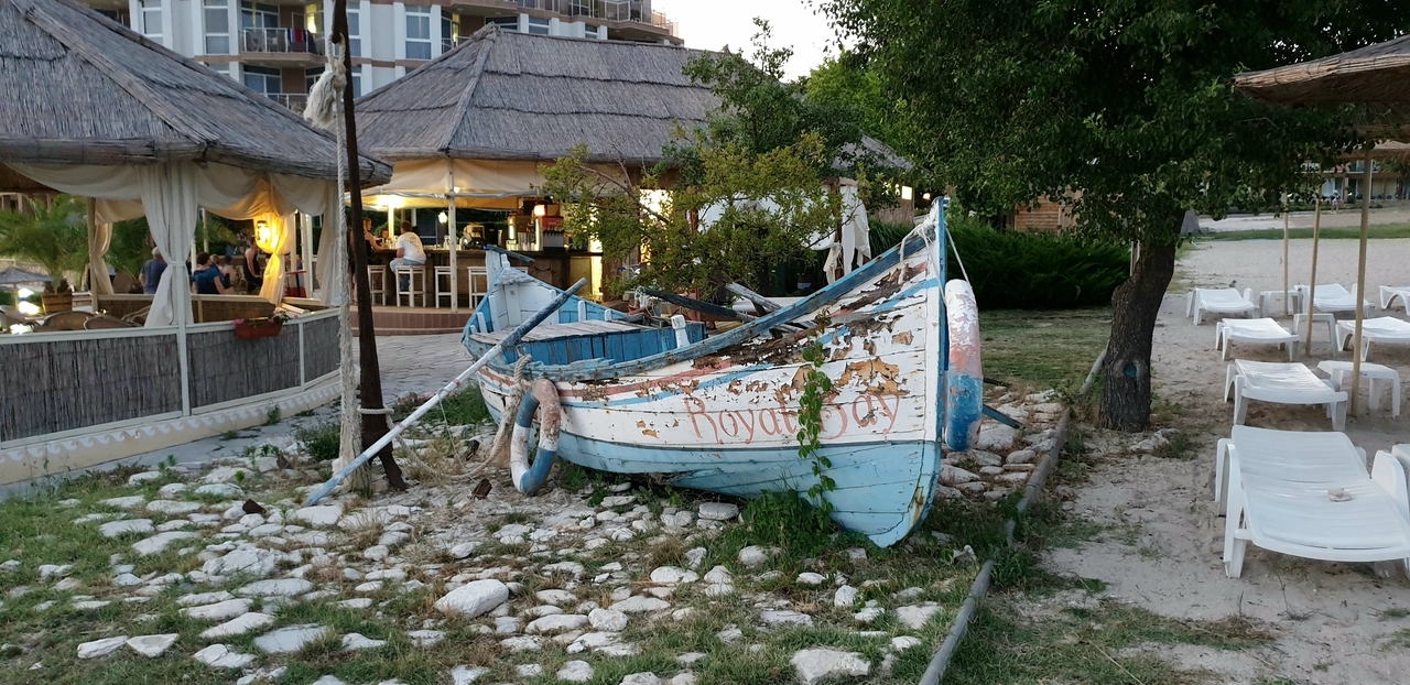 Stara łódka rybacka wyciągnięta na brzeg i postawiona w okolicach hotelu